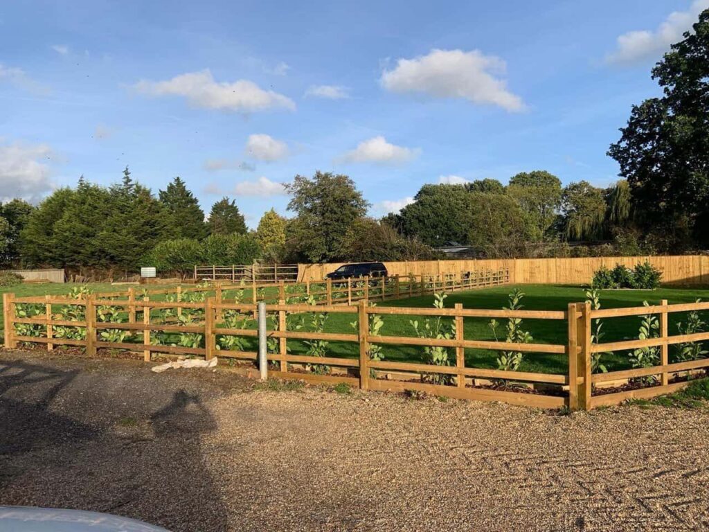 This is a photo of post and rail fencing with a gravel board installed at the base to create a flower bed, and at the rear is feather edge fencing along the edge of the garden. All works carried out by Fast Fix Fencing Fordham